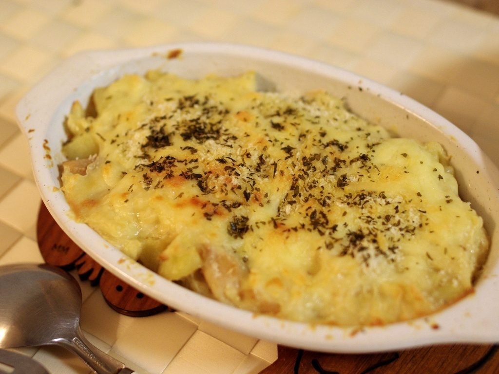 Gratin de pommes de terre fondant, doré au four dans un plat en porcelaine